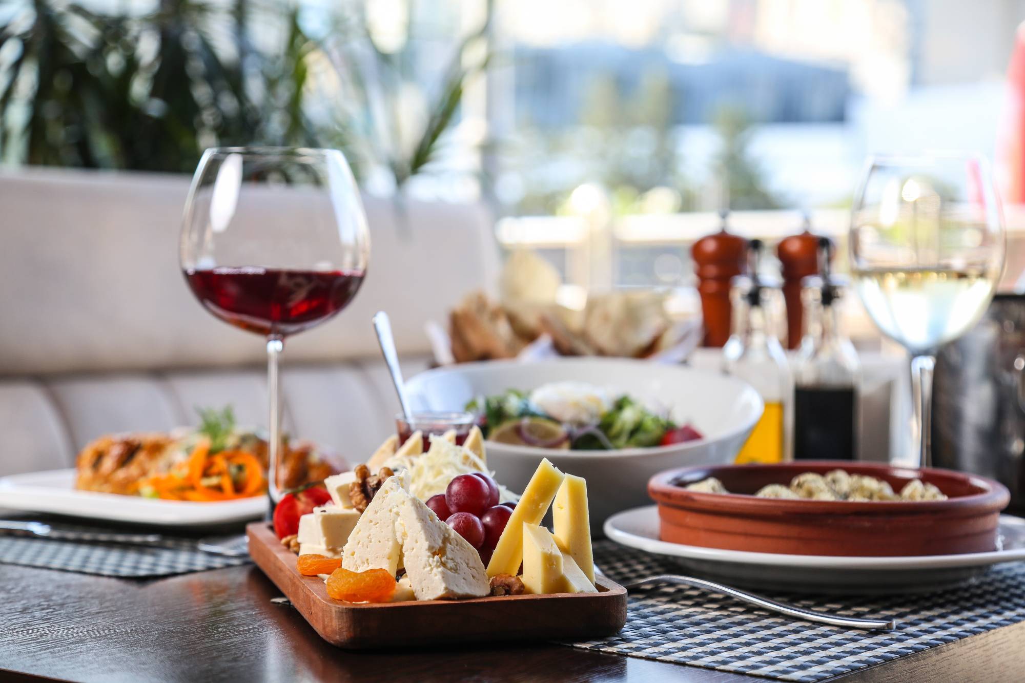 dinner set cheese plate main courses salad wine side view